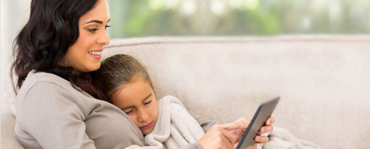 Mom with sick kid looking at a tablet